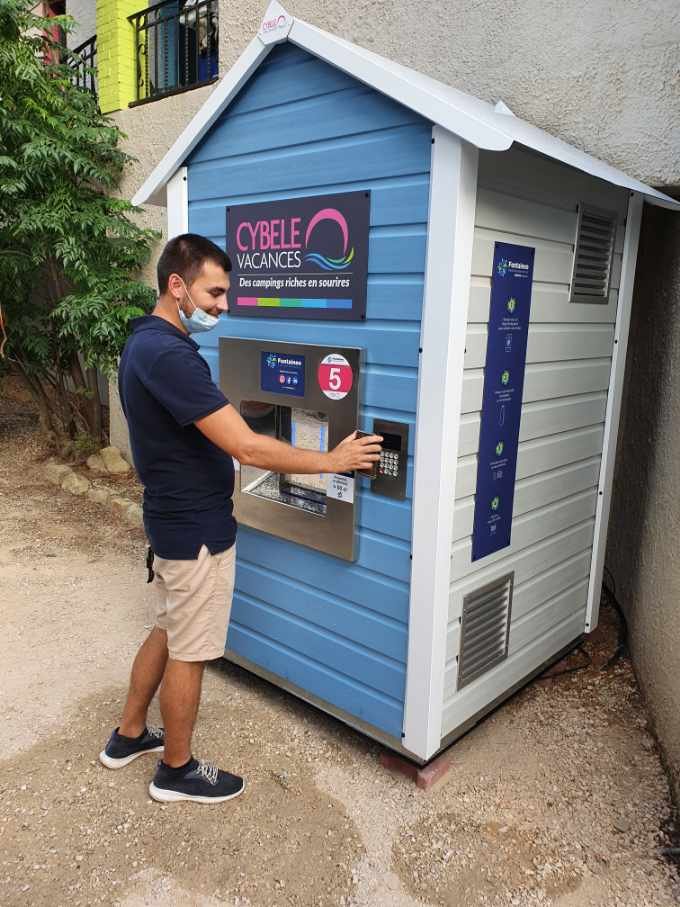 Un homme paye en sans contact sur une fontaine à eau Fontaineo.