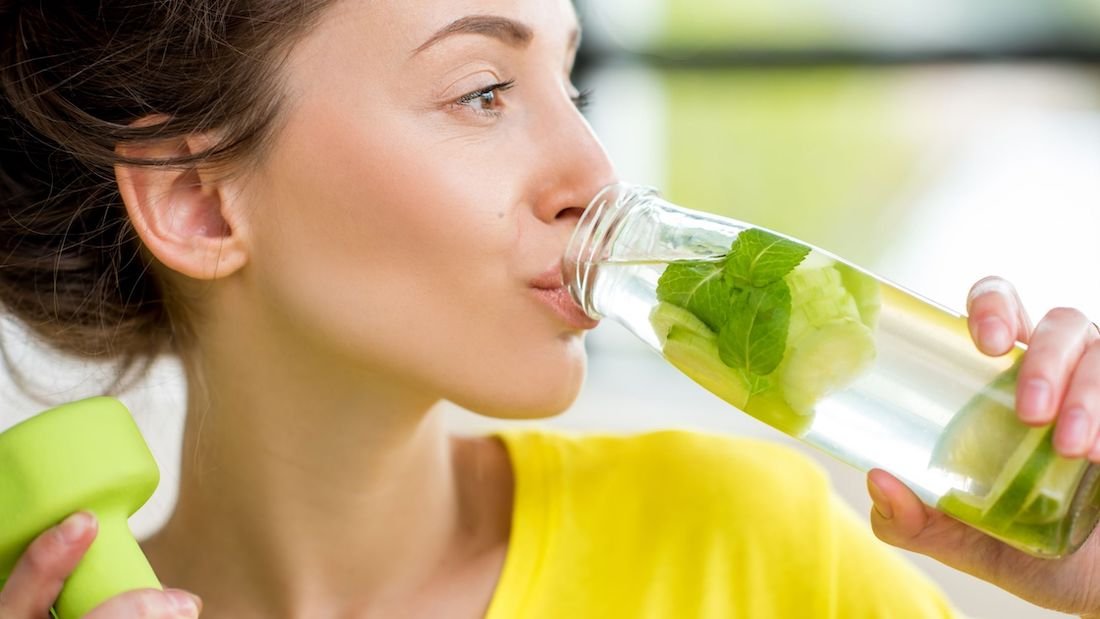 Femme buvant de l'eau dans une gourde