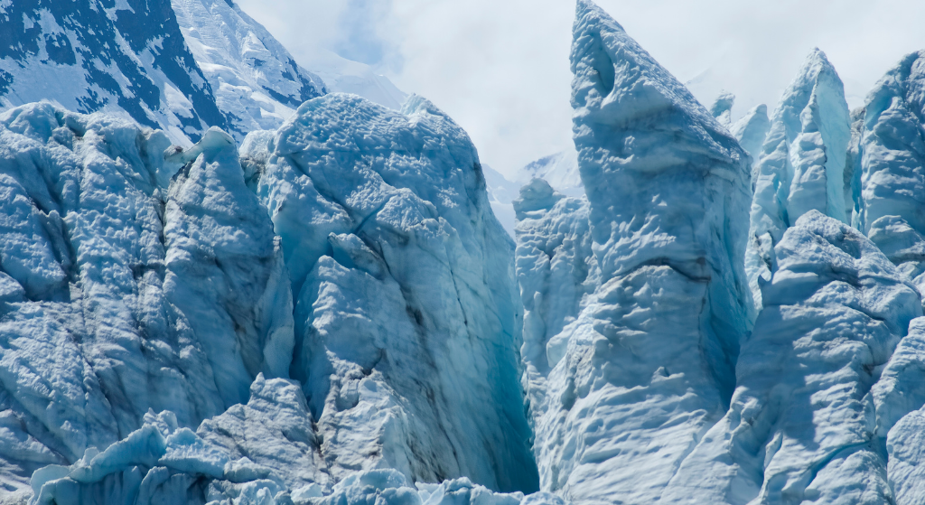 Gros plan sur un glacier, dont la surface glacée scintille tandis que de l'eau pure s'écoule à travers le paysage gelé.