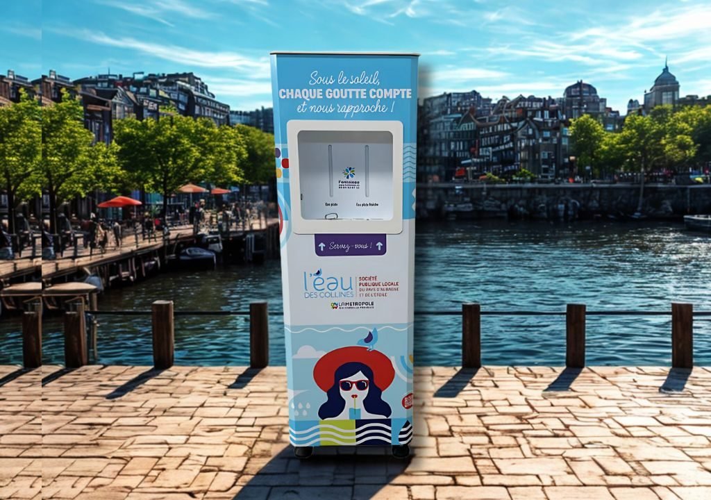 Un distributeur d'eau se trouve sur un quai en bois au bord de l'eau, avec des bâtiments et des arbres en arrière-plan. Le distributeur présente des graphiques colorés, dont une femme portant des lunettes de soleil, et un texte en français sur la conservation de l'eau.